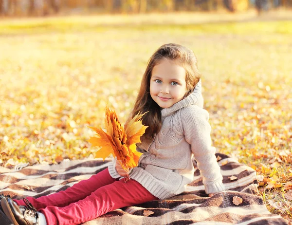 Carino bambino bambina con foglie di acero giallo in giorno d'autunno — Foto Stock