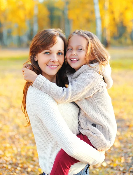 Счастливые улыбающиеся мать и ребенок веселятся вместе в осенний день — стоковое фото