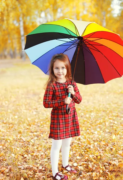 Criança menina bonita com guarda-chuva colorido no dia de outono — Fotografia de Stock