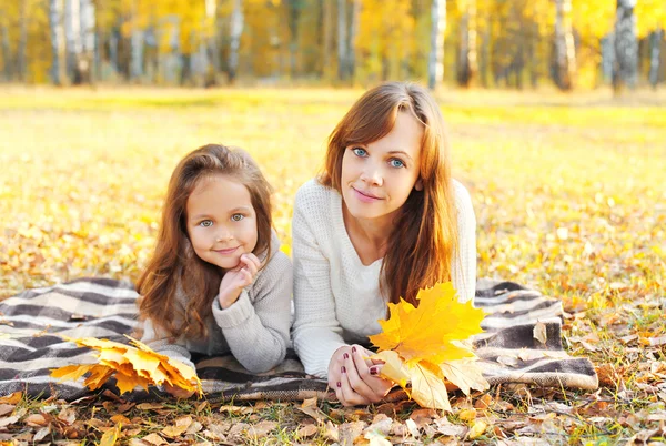 Mère et enfant avec des feuilles d'érable jaune le jour de l'automne — Photo