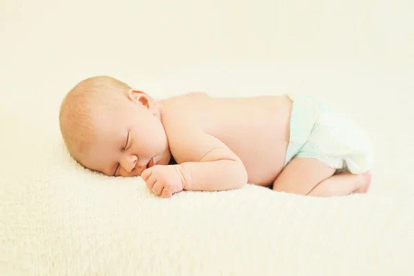 Bebê doce dormindo em seu estômago na cama em casa — Fotografia de Stock