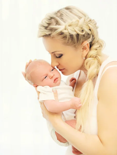 Älskande ung mamma håller på händer sovande spädbarn hemma — Stockfoto