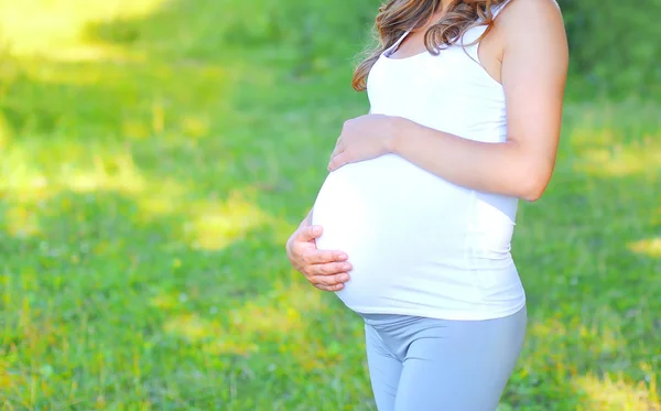 Беременная молодая женщина в теплый летний день крупным планом — стоковое фото