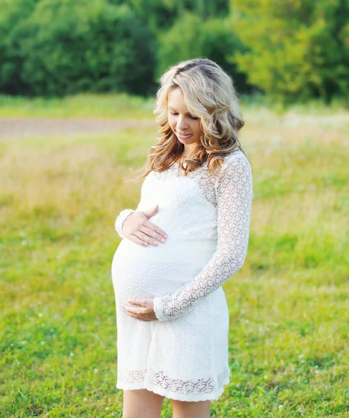 Açık havada doğa üzerinde beyaz elbiseli güzel hamile kadın — Stok fotoğraf