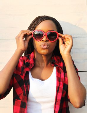 Beautiful young african woman in red sunglasses having fun