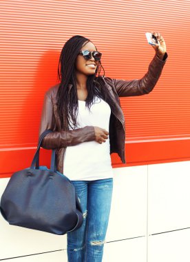 Beautiful smiling african woman taking self-portrait picture on