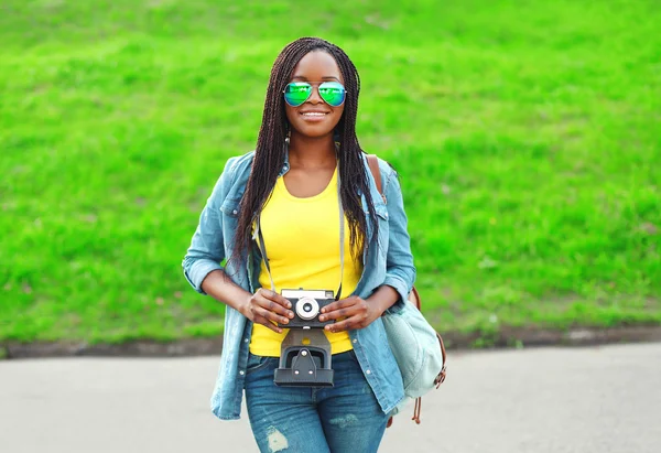 Hermosa joven africana sonriente con cámara retro vintage — Foto de Stock