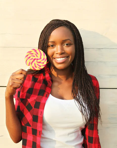 Retrato bela mulher africana sorridente feliz com doce pirueta — Fotografia de Stock