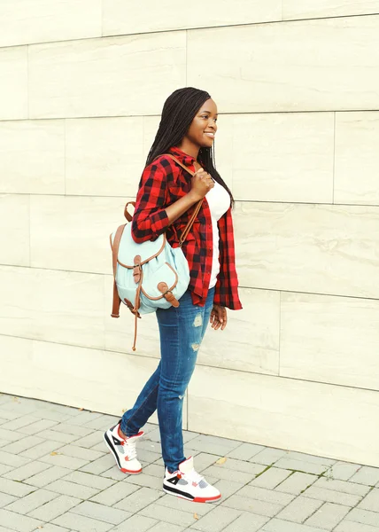 Muito sorridente jovem mulher africana com mochila andando na cidade — Fotografia de Stock