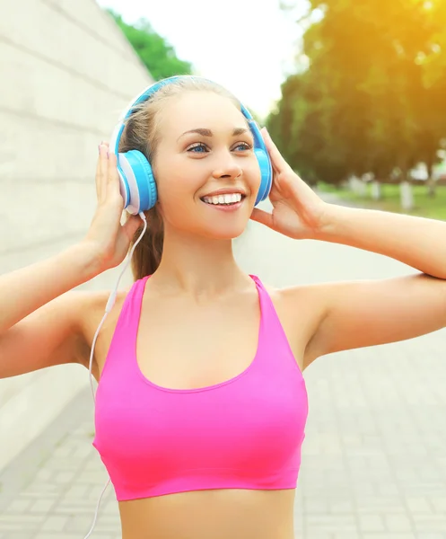 Retrato de fitness feliz mujer sonriente con auriculares escucha Imagen De Stock