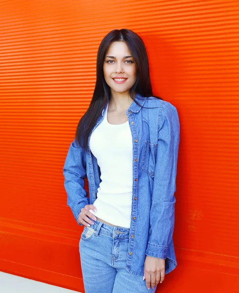 Schöne lächelnde junge Frau trägt eine blaue Jeans Kleidung über — Stockfoto