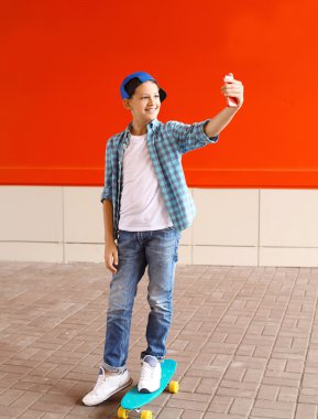Happy teenager boy taking picture self portrait on smartphone in