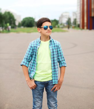 Portrait fashion child boy wearing a sunglasses and shirt outdoo