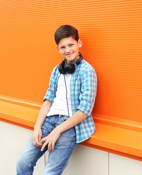 Beautiful smiling child boy wearing a shirt and headphones in ci — Stock fotografie