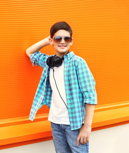 Hermoso niño sonriente con gafas de sol y auriculares —  Fotos de Stock