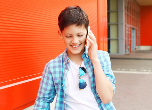 Portrait smiling teenager boy talking on the phone in city — Stock fotografie