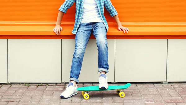 Stylish teenager boy wearing a checkered shirt and jeans on skat — Stockfoto