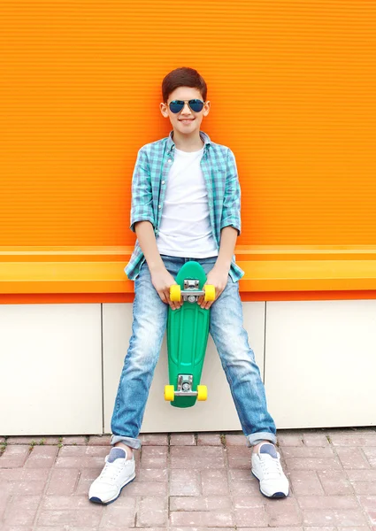 Stylish teenager boy wearing a checkered shirt, sunglasses and s — Stockfoto