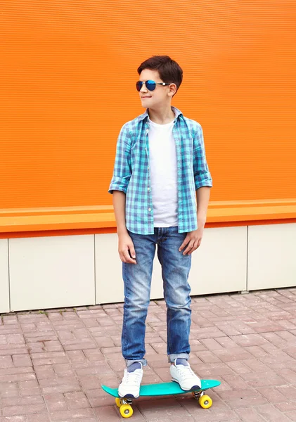 Stylové dospívající chlapec kostkovaná košile, brýle na sk — Stock fotografie