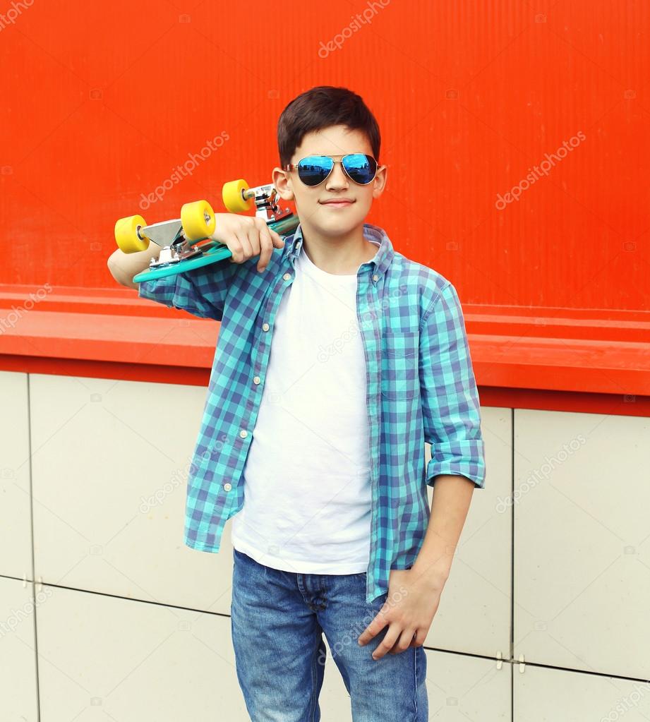 Stylish teenager boy wearing a checkered shirt and sunglasses wi