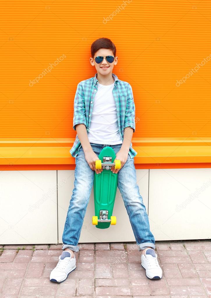 Stylish teenager boy wearing a checkered shirt, sunglasses and s