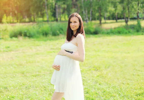 Bella giovane donna incinta in abito bianco sulla natura — Foto Stock