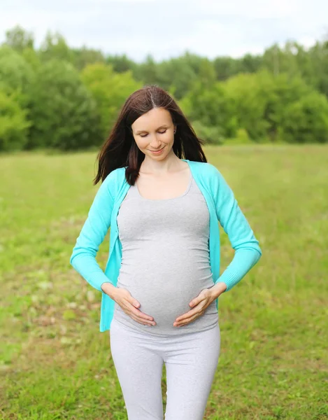 Portrait smiling pregnant woman outdoors in summer day — Stock Photo, Image