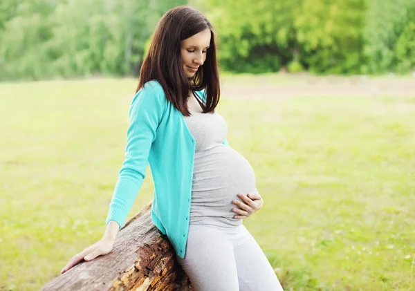 Unga gravid kvinna vilar utomhus i sommardag — Stockfoto