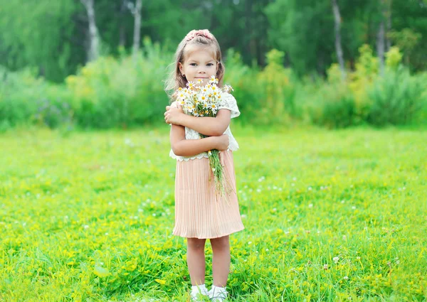 Schöne kleine Mädchen Kind mit Strauß Kamillenblüten in s — Stockfoto