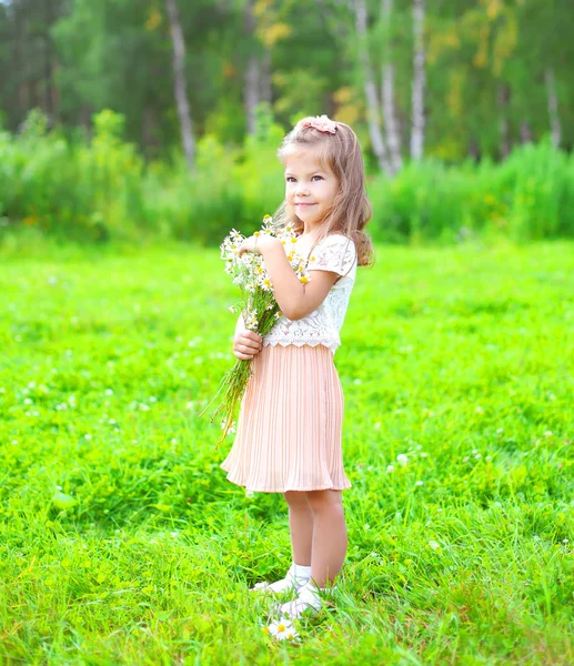 Niedliches kleines Mädchen Kind mit Strauß Kamillenblüten im Sommer — Stockfoto