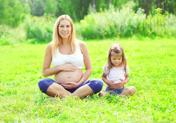 Happy pregnant woman, mother and little daughter child sitting o — 图库照片