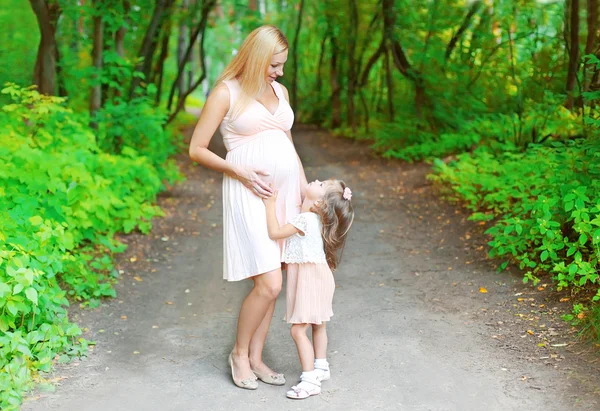 Pregnant woman, mom and little daughter child walking together i — 图库照片