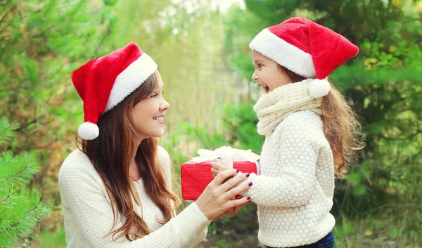 Conceito de Natal e família - criança e mãe em santa vermelha ha — Fotografia de Stock