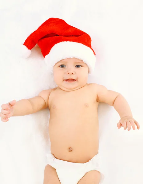 Christmas and family concept - cute smiling baby in red santa ha — Stok fotoğraf