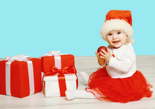 Christmas and people concept - smiling child in santa red hat wi