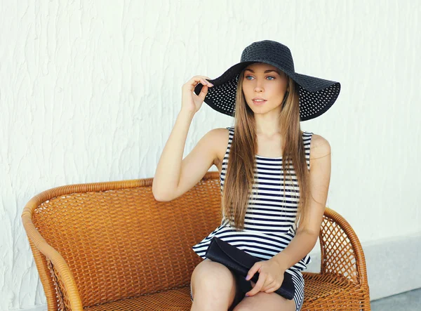 Krásná mladá žena na sobě pruhované šaty, černé slaměný klobouk — Stock fotografie