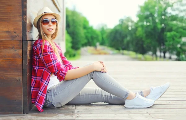 Pembe gömlek ve r oturan yaz şapka giyen genç ve güzel kadın — Stok fotoğraf