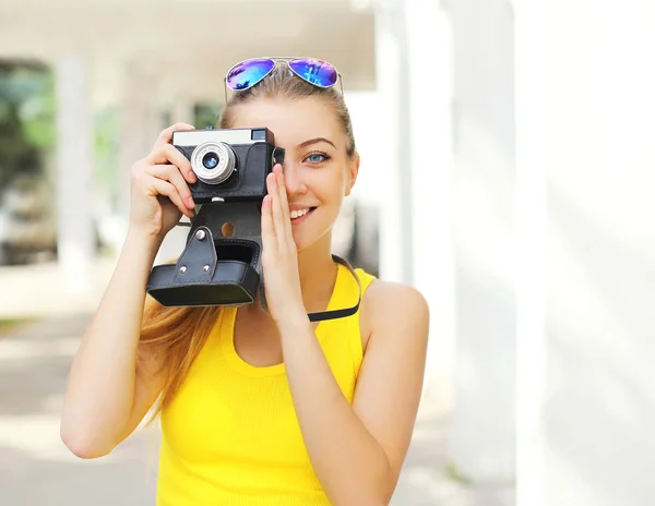 Happy pretty smiling young woman with retro vintage camera in ci — Stock Photo, Image