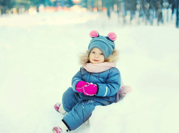 Onnellinen pieni lapsi leikkii lunta talvipäivänä — kuvapankkivalokuva