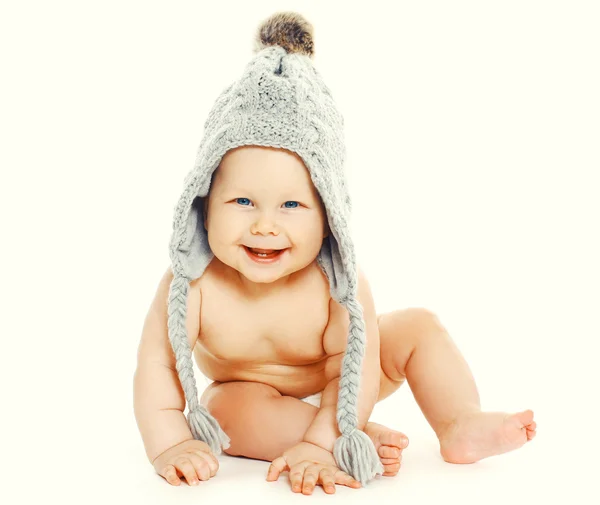 Portrait of happy smiling baby sitting in grey knitted hat — Stock Photo, Image
