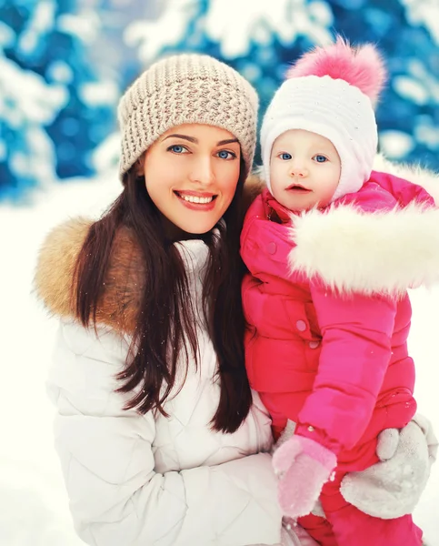 Stående glada leende mor och barn i snöig vinterdag — Stockfoto