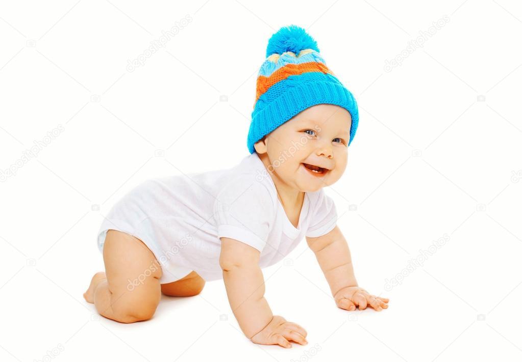 Portrait happy smiling cheerful baby crawls in knitted hat on a