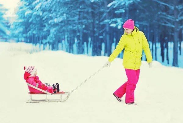 Glad mamma och barn gå i vinter skog. Mamma med barn o — Stockfoto