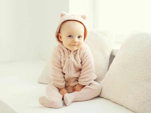 Lindo sonriente bebé sentado en blanco habitación en casa —  Fotos de Stock