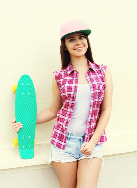 Moda hipster chica cool en ropa rosa colorido con skateboa — Foto de Stock