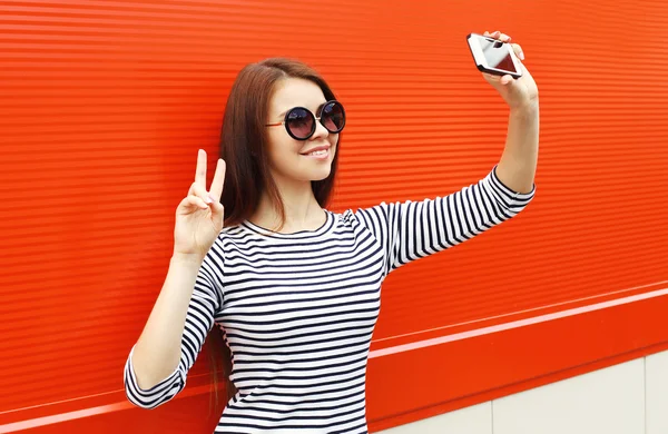 Fashion pretty woman wear a sunglasses and striped dress makes s — Stock Photo, Image