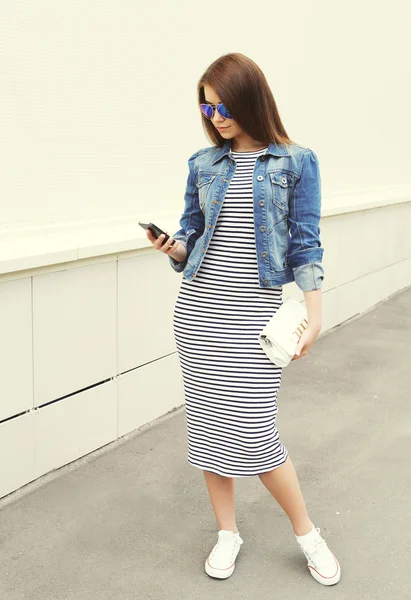 Mode jolie fille en utilisant smartphone en ville sur backgrou blanc — Photo