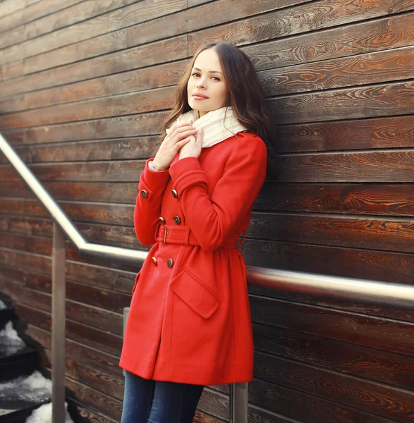 Hermosa mujer joven con un abrigo rojo y bufanda en la ciudad — Foto de Stock