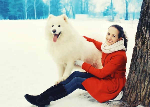 Happy souriant jeune femme propriétaire avec blanc Samoyed chien sur neige i — Photo