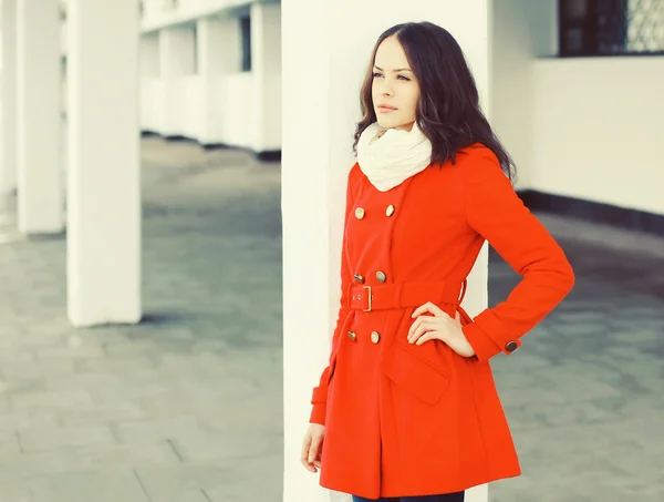 Mujer joven y bonita con un abrigo rojo y una bufanda en la ciudad — Foto de Stock